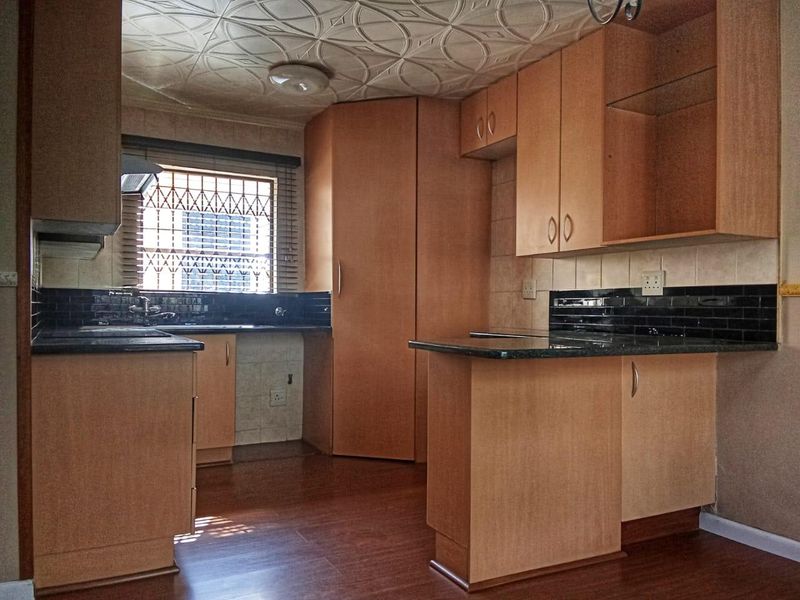 A functional kitchen featuring laminate cabinetry, granite countertops, and a subway tile backsplash, offering a clean, blank canvas for potential modern updates.