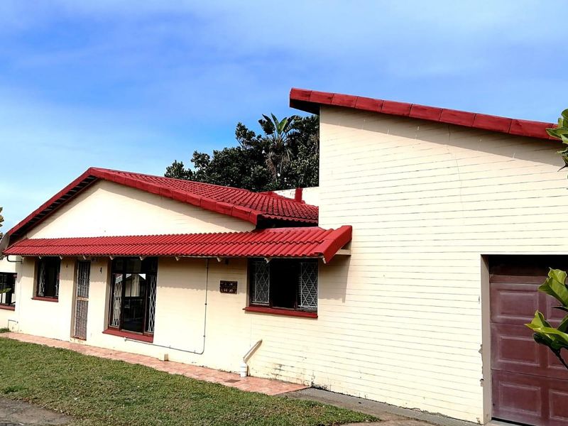Front elevation of a townhouse featuring a tiled roof, brick exterior, and an integrated garage.