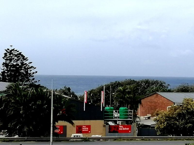 An elevated view overlooking the surrounding neighborhood with a distant ocean horizon in the background.