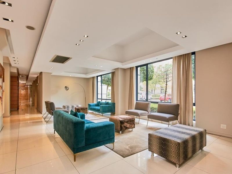 Spacious, modern living area featuring polished tile flooring, recessed ceiling lighting, and large windows providing ample natural light.