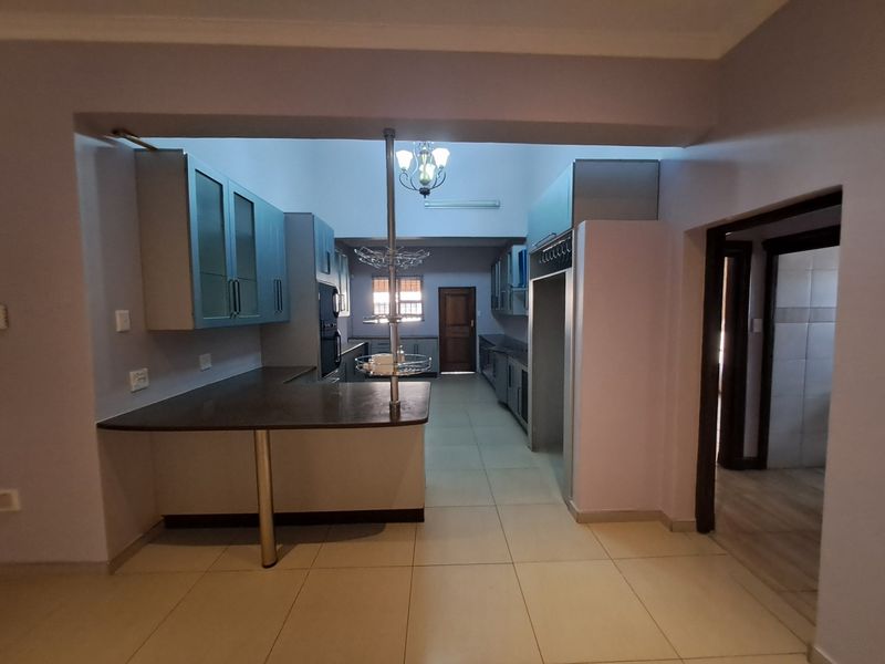 Spacious kitchen featuring extensive built-in cabinetry, a breakfast bar, and tiled flooring, offering a functional layout ready for modern updates.