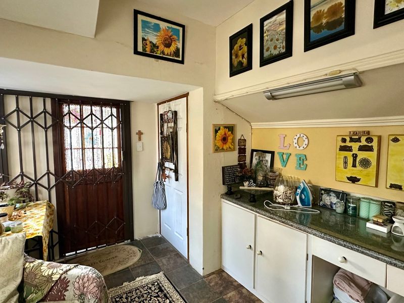 An entry area featuring tiled flooring, built-in cabinetry with stone countertops, and a secure metal gate at the main entrance.