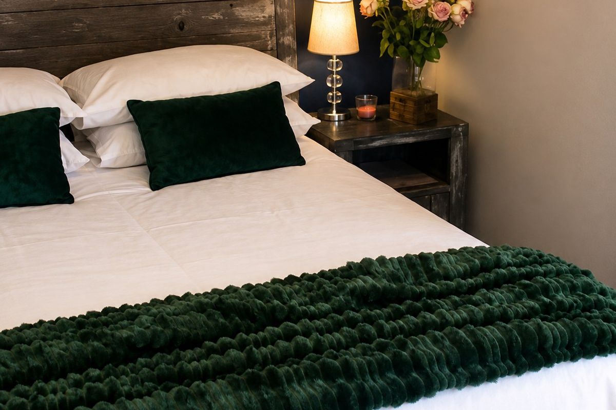 A cozy bedroom featuring a dark blue accent wall and neutral tones, creating a comfortable and inviting sleeping space.