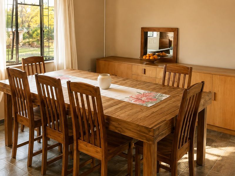 A dining room featuring tiled flooring, a large steel-framed window, and built-in wooden cabinetry providing ample storage space.