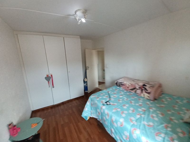 A bedroom featuring laminate flooring and built-in cupboards, providing functional storage space.