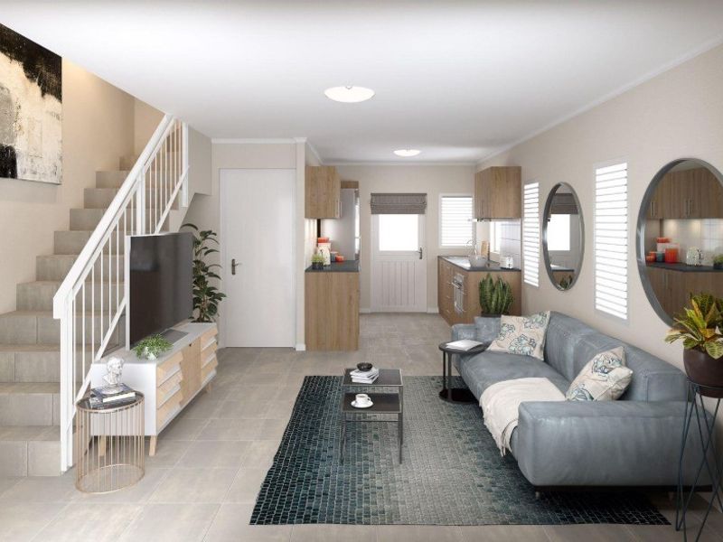 A modern open-plan living area featuring a staircase, tiled flooring, and a functional kitchen space with contemporary cabinetry.