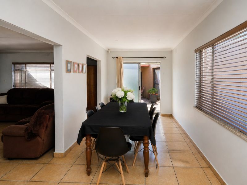 Dining area featuring tiled flooring, coved ceilings, and a sliding glass door providing access to the exterior.