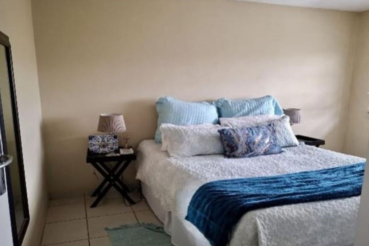 A standard bedroom featuring tiled flooring and neutral wall finishes, providing a functional space for rest.