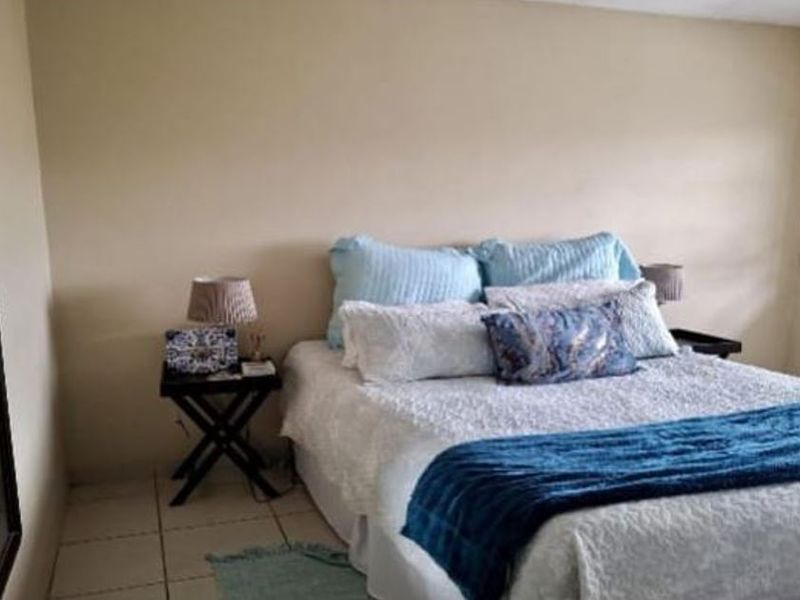 A standard bedroom featuring tiled flooring and neutral wall finishes, providing a functional space for rest.