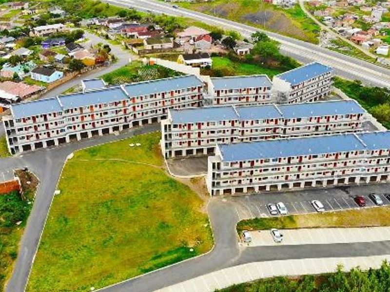 Aerial view of a multi-story apartment complex featuring paved parking areas and surrounding residential neighborhood infrastructure.