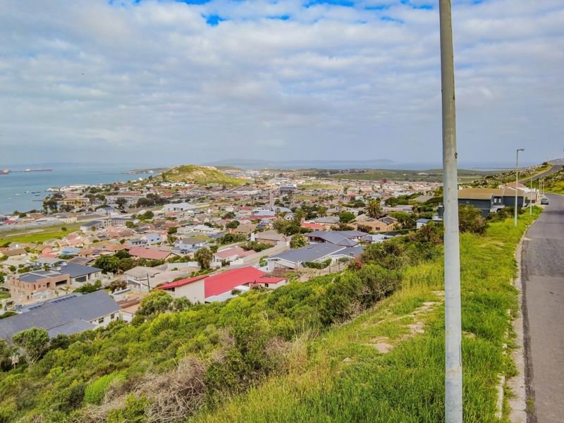 Elevated panoramic view overlooking the coastal residential neighborhood, surrounding landscape, and ocean horizon.