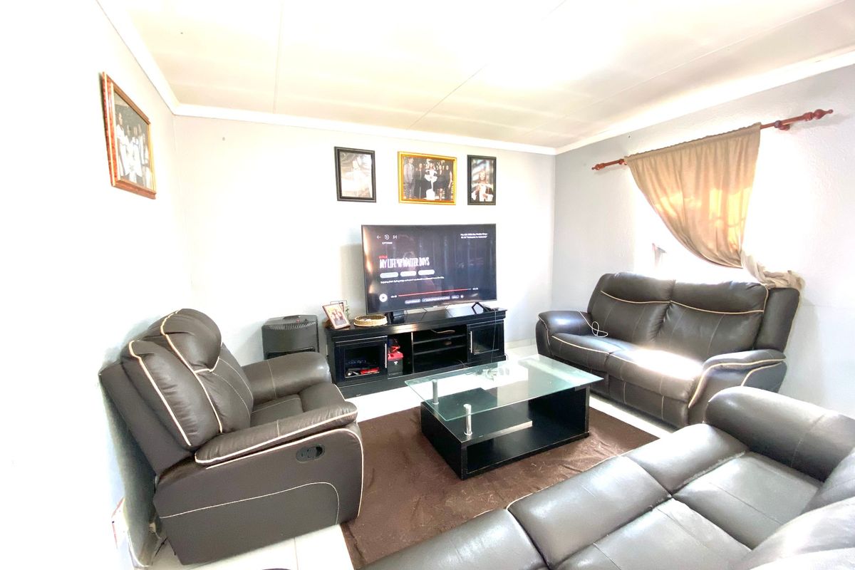 A functional living room featuring tiled flooring and a neutral wall finish, providing a comfortable space for relaxation and entertainment.