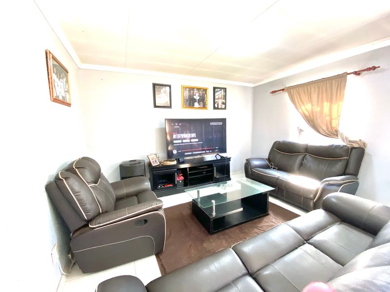 A functional living room featuring tiled flooring and a neutral wall finish, providing a comfortable space for relaxation and entertainment.