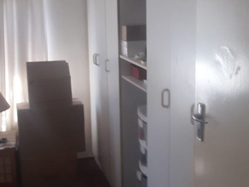 A bedroom featuring built-in cupboards with white doors, providing ample storage space.