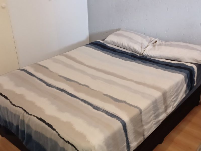 A compact bedroom featuring laminate flooring and a built-in wardrobe, requiring minor cosmetic updates to the wall finishes and skirting boards.
