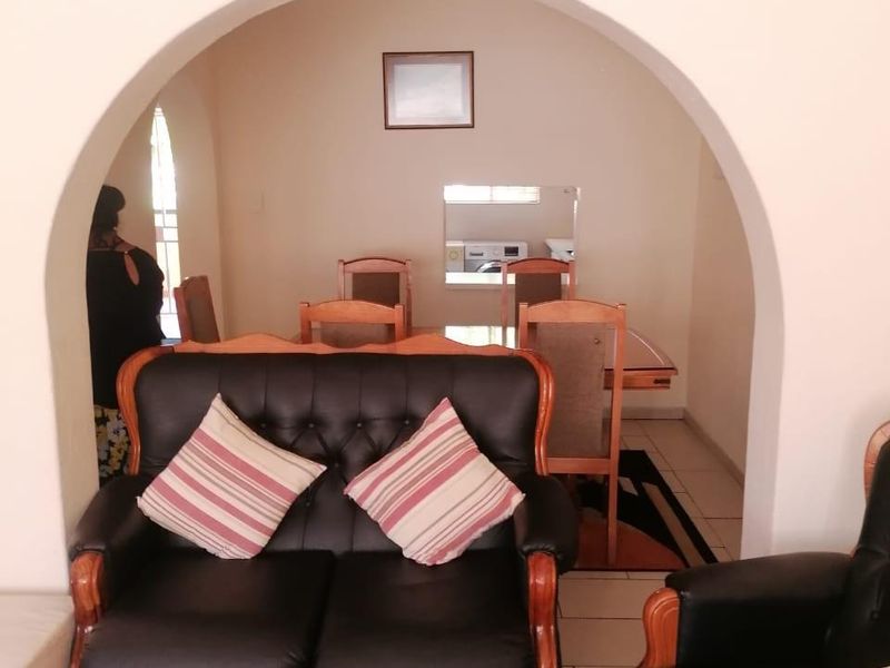 Open plan living and dining area featuring tiled flooring and a distinctive arched architectural transition between the two spaces.