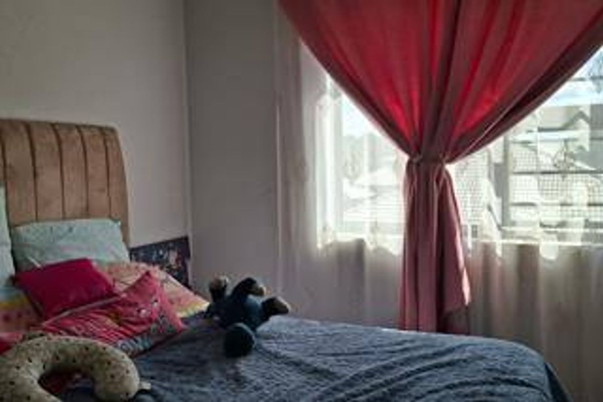 A bedroom featuring a window with curtains, providing natural light to the space.