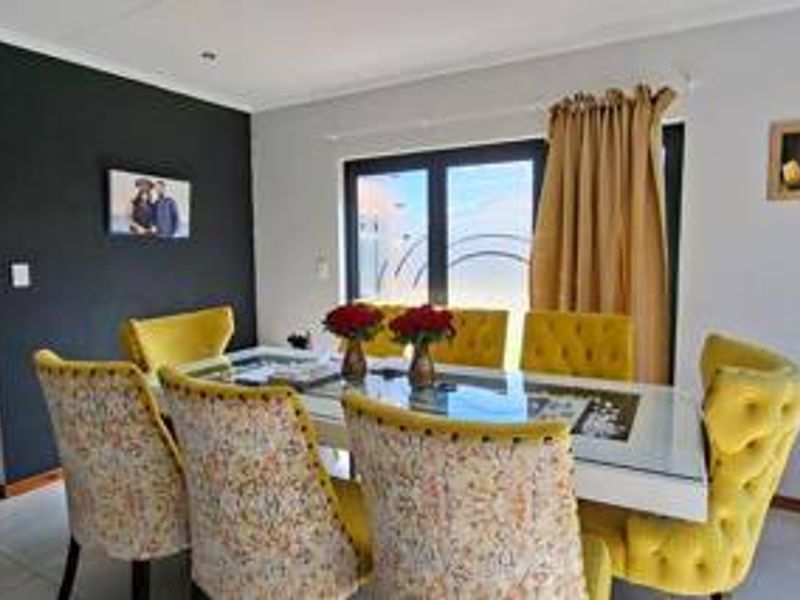A bright dining room featuring tiled flooring, recessed downlighting, and a sliding glass door providing access to the exterior.