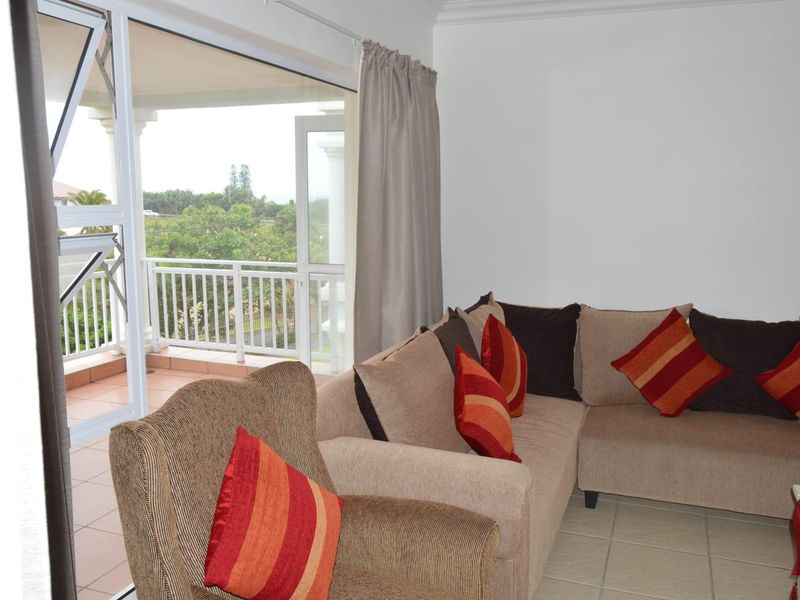 A living room featuring tiled flooring and a large sliding glass door providing direct access to an outdoor balcony area.