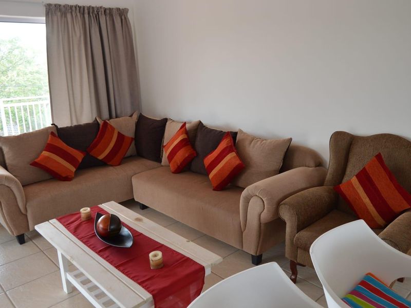 A comfortable living room area featuring tiled flooring and a sliding glass door providing access to an outdoor space.
