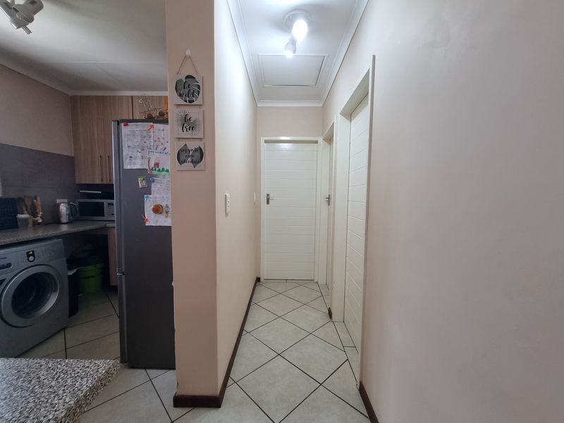 A functional hallway featuring tiled flooring and access to adjacent rooms, connecting the living area to the rest of the apartment.