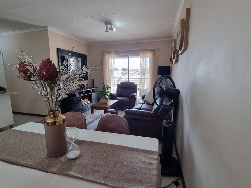 Open plan living and dining area featuring tiled flooring and a sliding glass door providing access to the balcony.