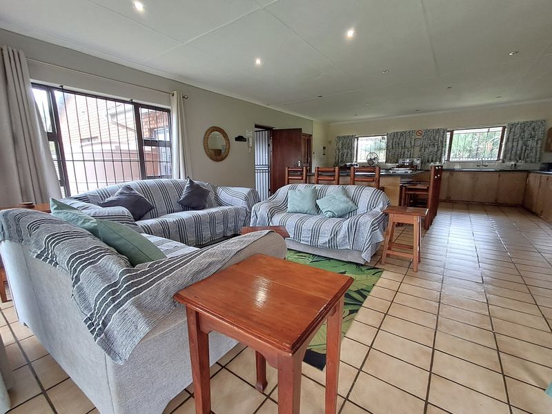Spacious open-plan living and kitchen area featuring tiled flooring, recessed lighting, and a functional kitchen island layout.