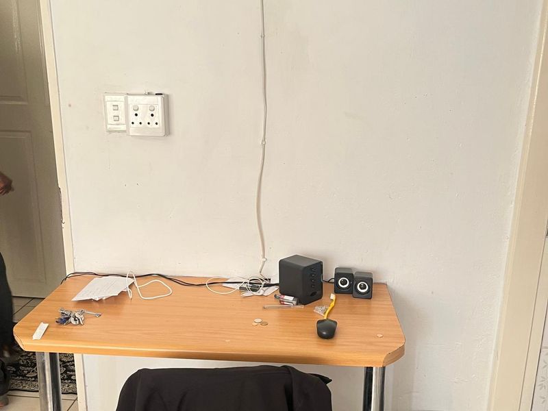 A small interior space featuring a desk area with wall-mounted electrical outlets.