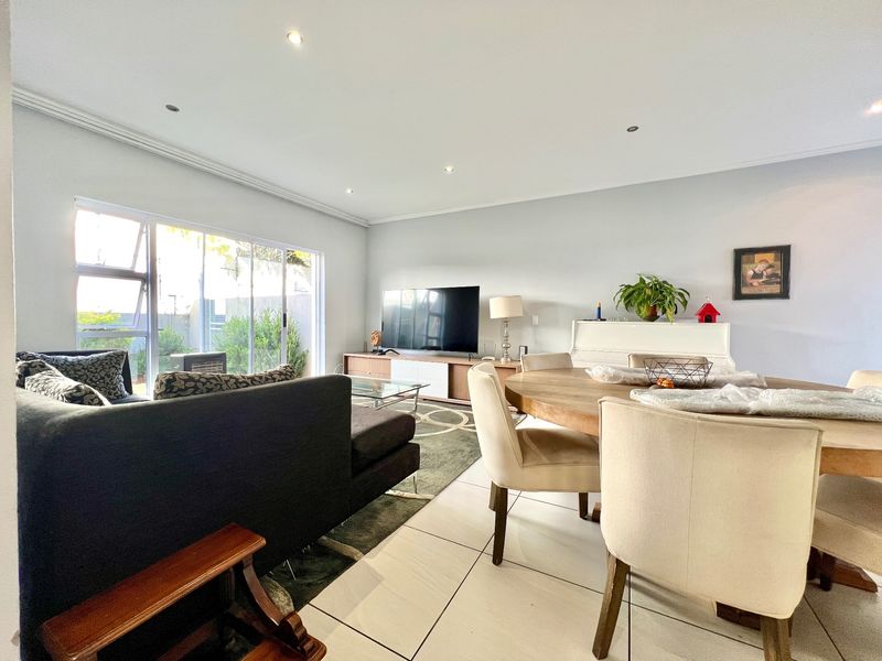 Spacious open-plan living and dining area featuring large sliding glass doors that provide ample natural light and direct access to the outdoor space.