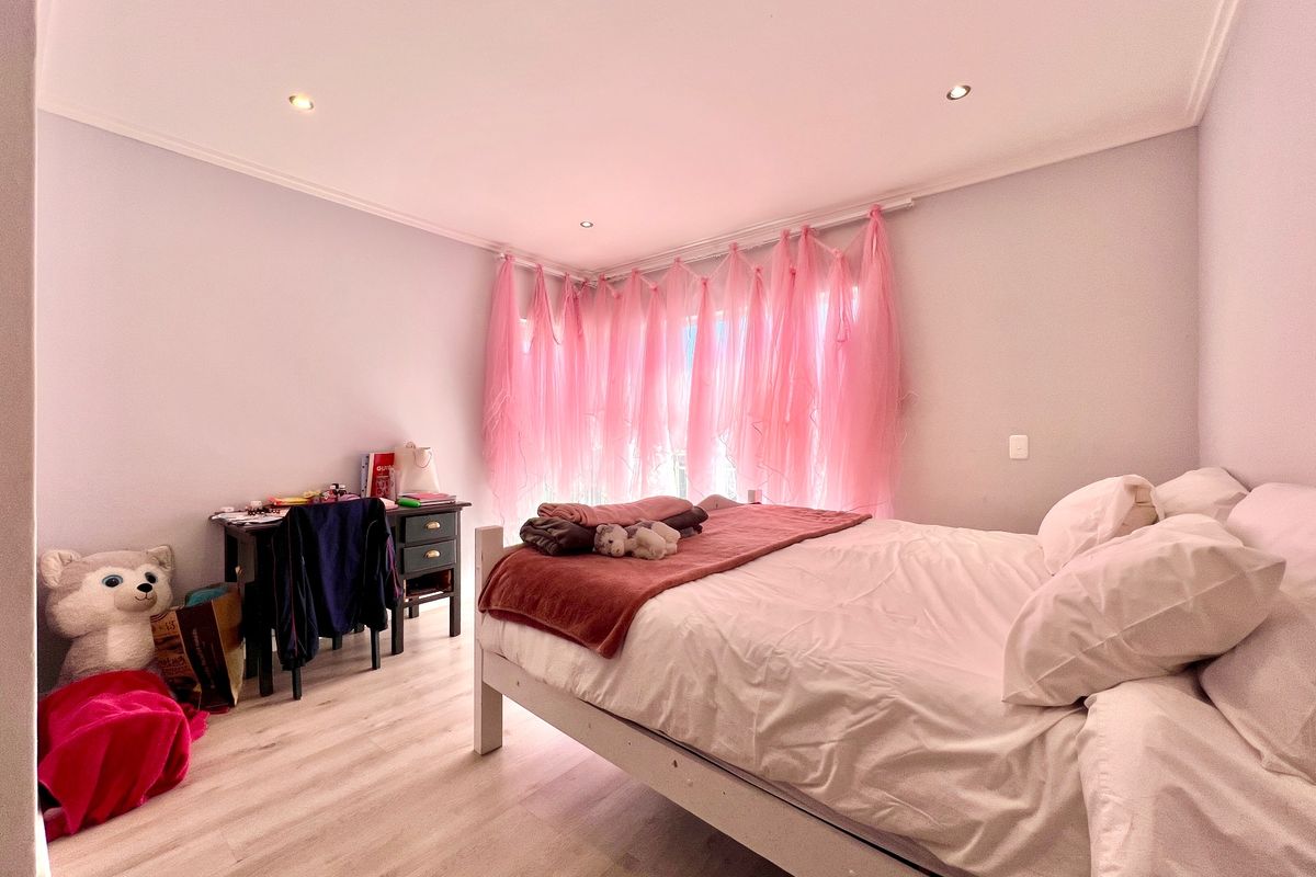 A well-lit bedroom featuring light-toned laminate flooring and recessed ceiling downlights, providing a clean and neutral foundation for the space.