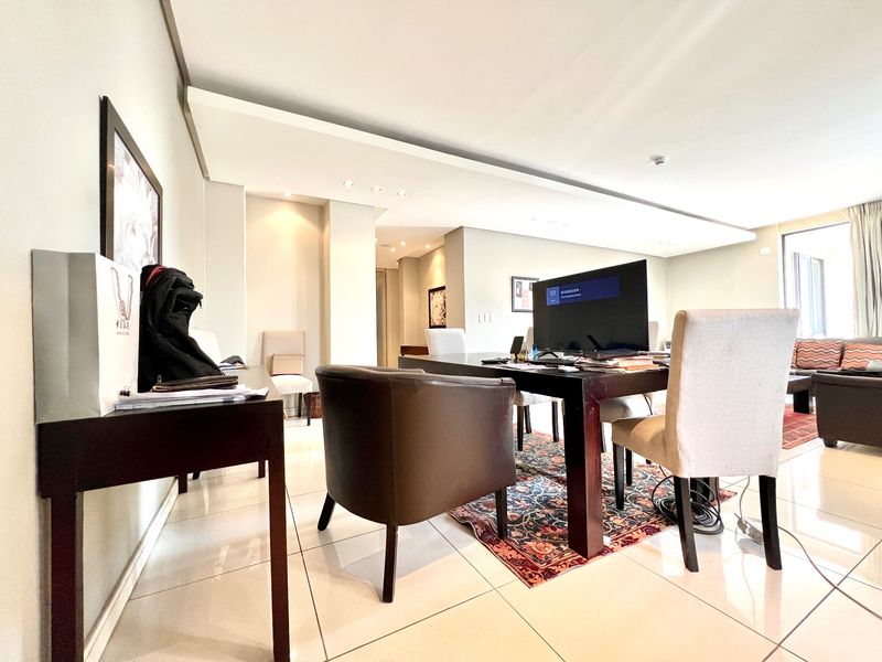Spacious living area featuring modern tiled flooring, a bulkhead ceiling with recessed lighting, and an open-plan layout.