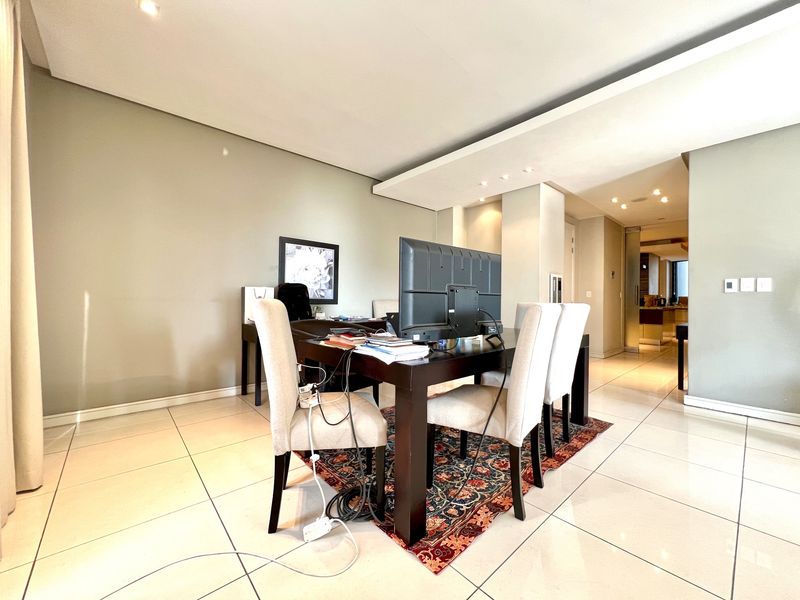 Spacious open-plan living area featuring modern tiled flooring, recessed ceiling lighting, and a contemporary bulkhead design, creating a bright and versatile living space.