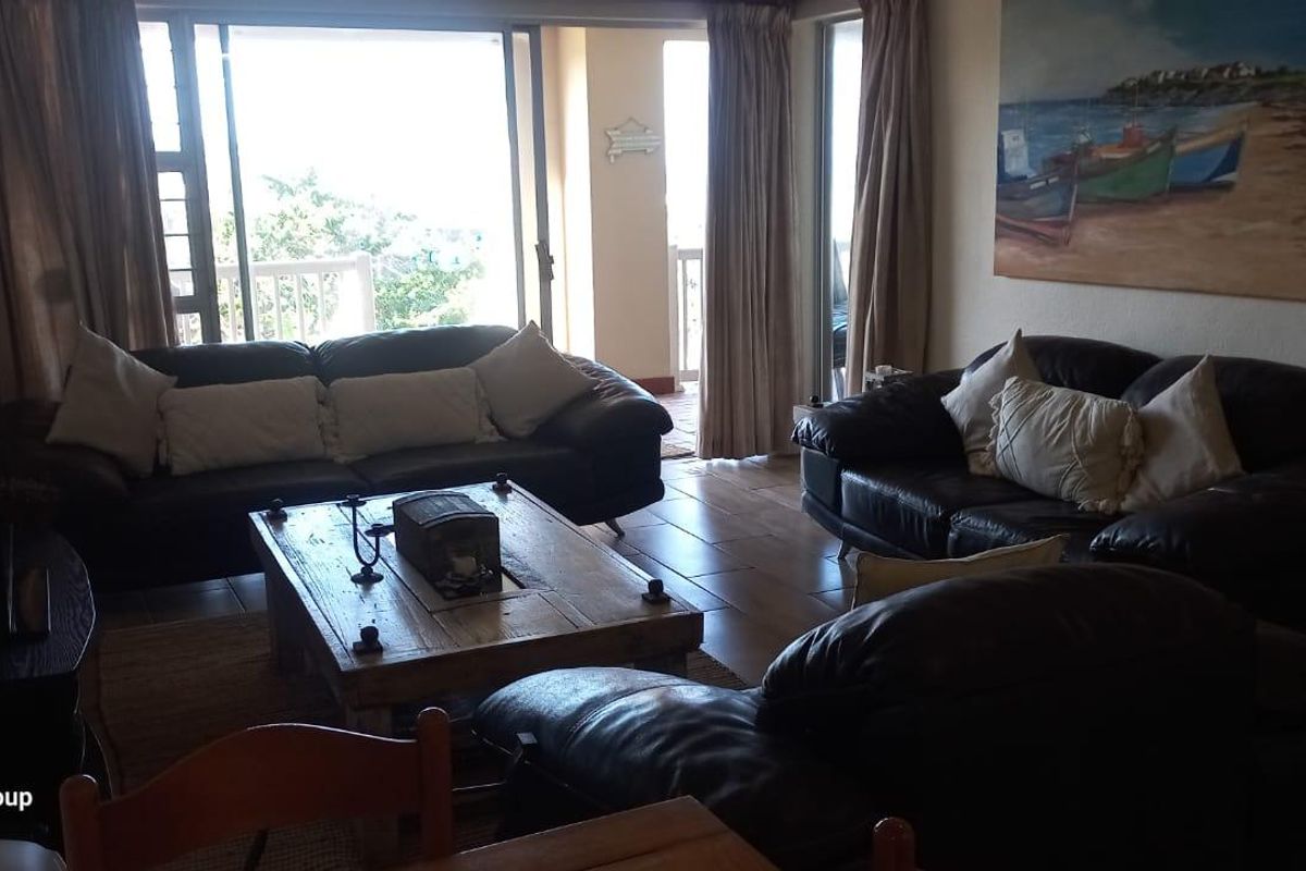 Spacious living room featuring tiled flooring and large sliding glass doors that provide natural light and direct access to the balcony.