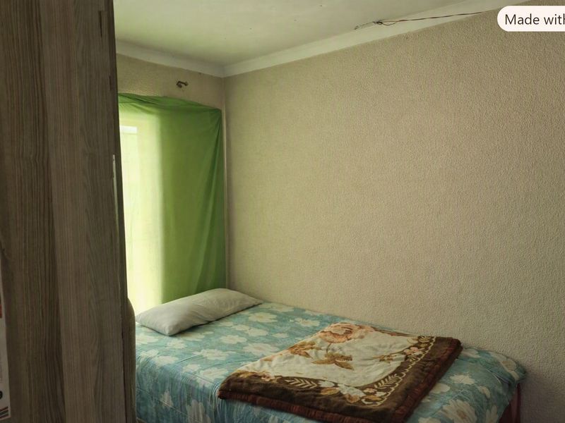 A compact bedroom featuring textured wall finishes and coving, currently requiring maintenance to address exposed wiring and general wear.