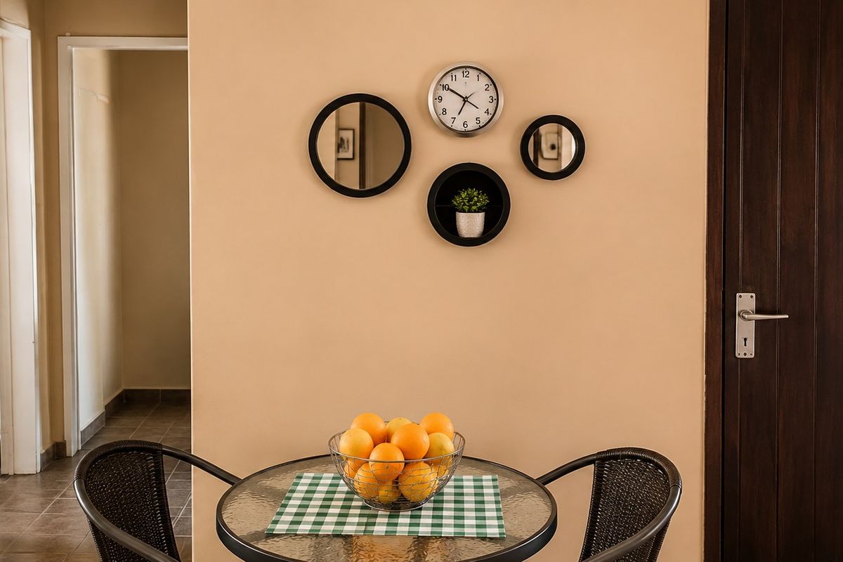 A view of a living area featuring tiled flooring and a solid wood door, providing access to adjacent rooms.
