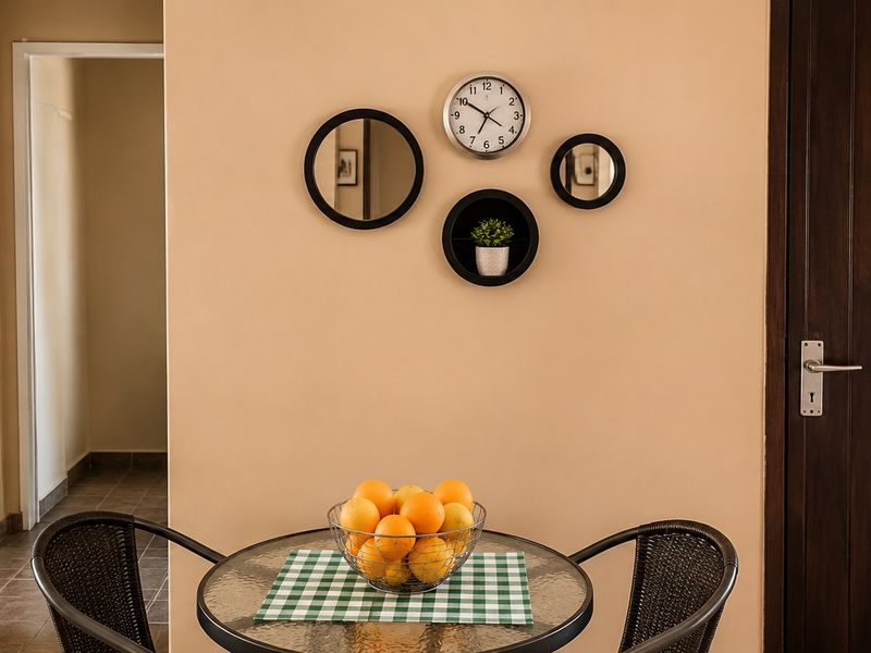 A view of a living area featuring tiled flooring and a solid wood door, providing access to adjacent rooms.