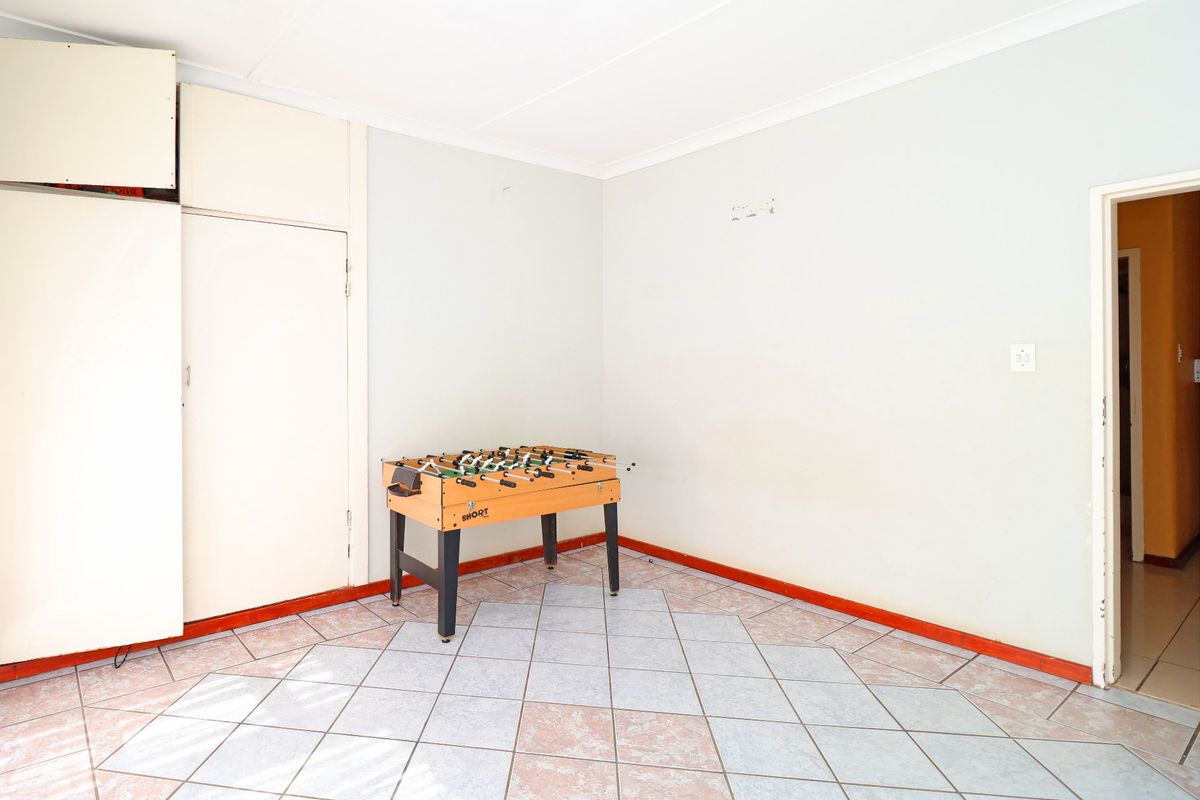 A vacant living area featuring tiled flooring and built-in storage cupboards, offering a blank canvas for potential interior design updates.
