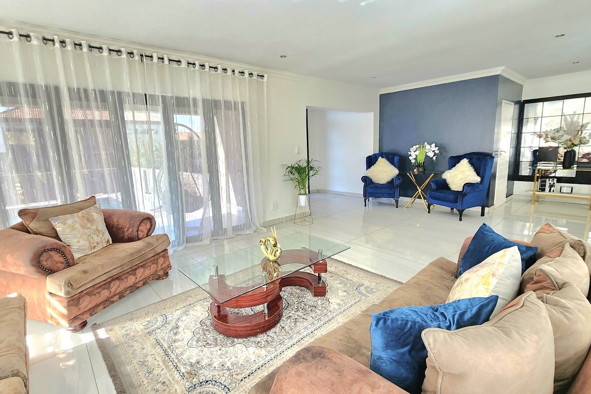 Spacious living room featuring polished tiled flooring, recessed lighting, and large sliding glass doors that provide ample natural light and access to the outdoors.