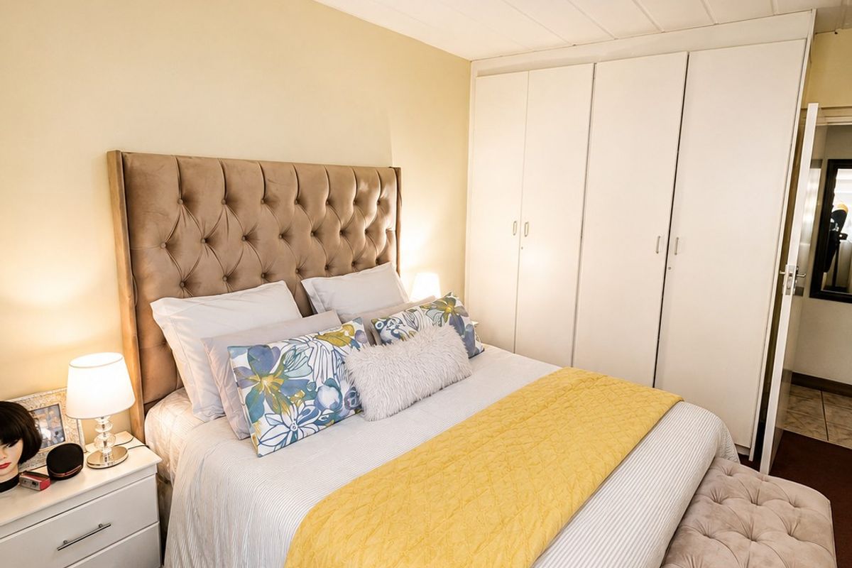 A well-maintained bedroom featuring a built-in wardrobe and neutral wall finishes, providing a functional and comfortable sleeping space.