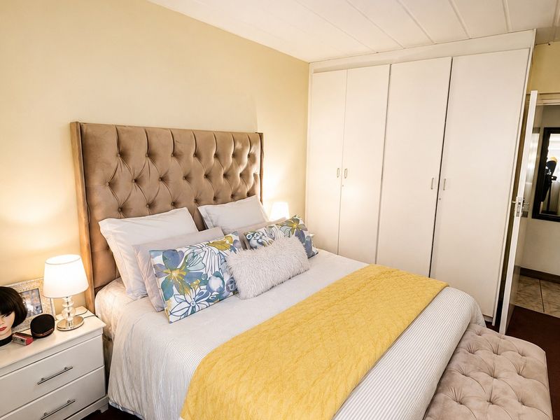 A well-maintained bedroom featuring a built-in wardrobe and neutral wall finishes, providing a functional and comfortable sleeping space.