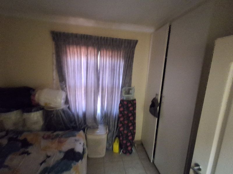 A bedroom featuring tiled flooring and a built-in wardrobe, providing functional storage space.