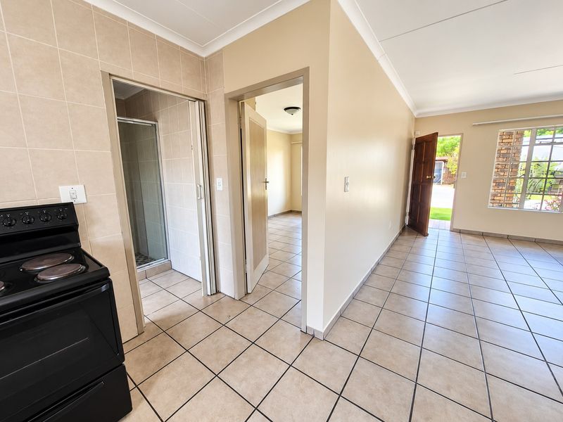 Open plan living area featuring tiled flooring, a built-in shower, and direct access to the exterior, offering a functional and versatile layout.
