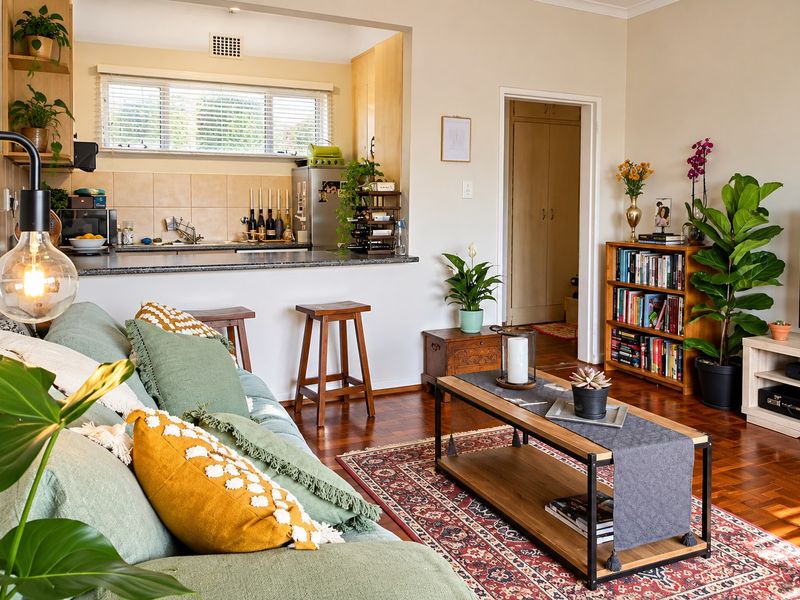 Open plan living area featuring parquet flooring and a functional kitchen with granite countertops, seamlessly connecting to the rest of the apartment.