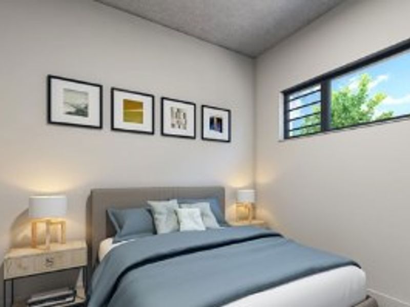 A modern bedroom featuring a horizontal sliding window and a textured ceiling, providing a clean and well-maintained living space.