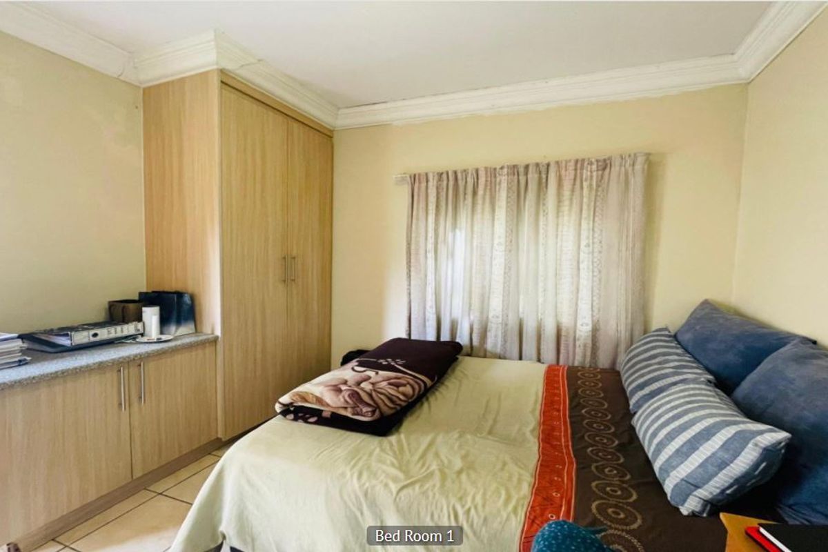 A bedroom featuring built-in wooden cabinetry, tiled flooring, and crown molding, providing functional storage and a neutral base for interior design.