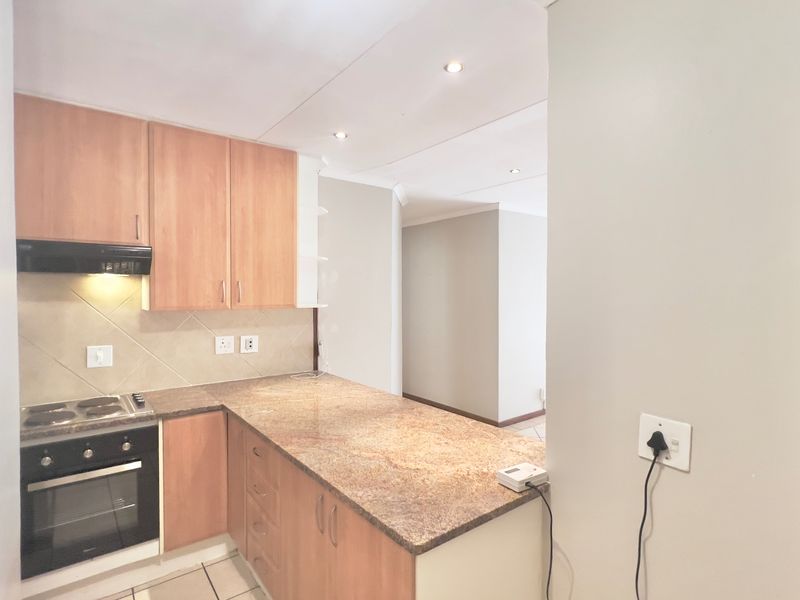 A functional kitchen featuring wood-finish cabinetry, granite countertops, and built-in appliances, offering a clean and practical workspace.