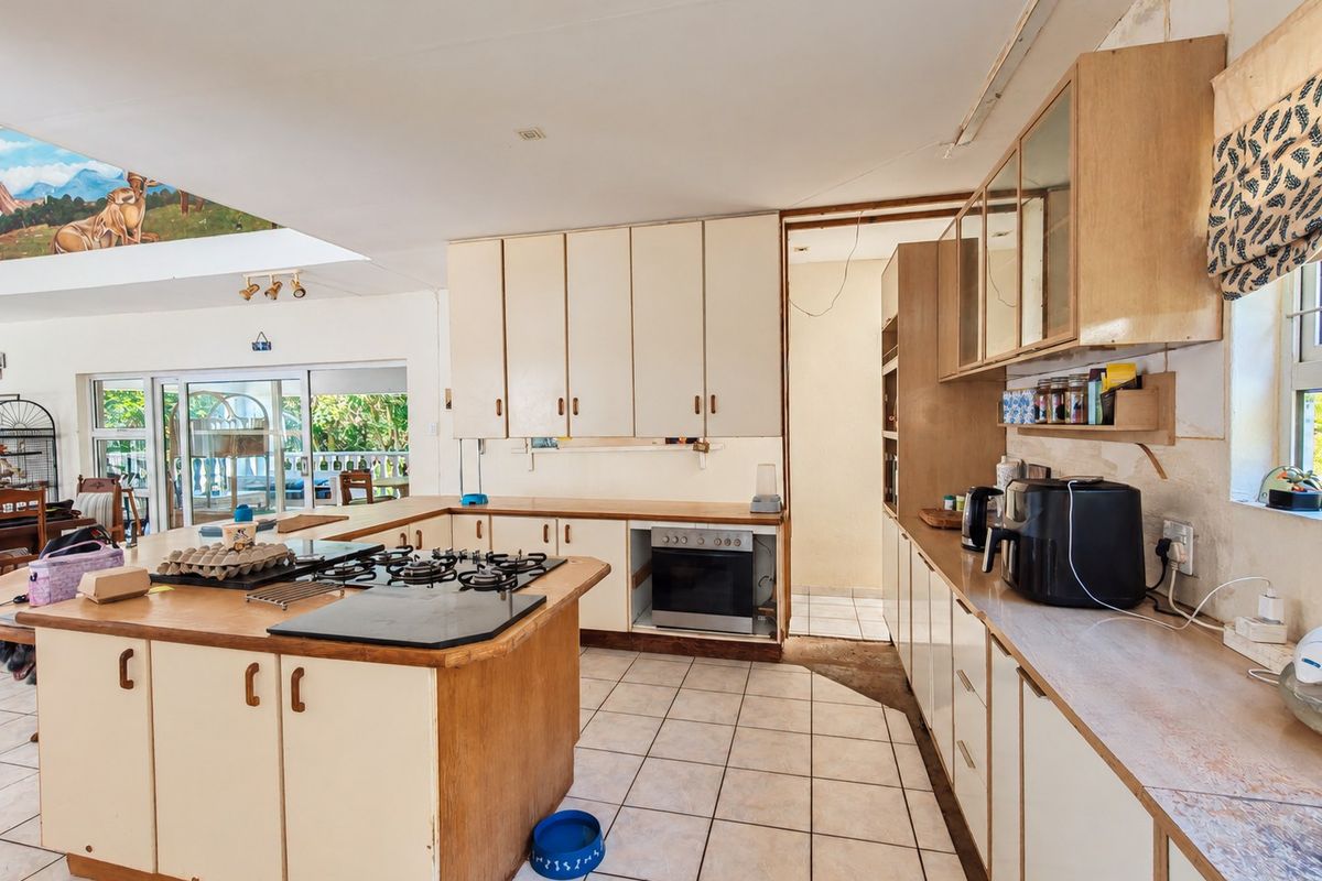 Spacious kitchen featuring built-in cabinetry, a gas hob, and tiled flooring, offering significant potential for modernization and renovation.