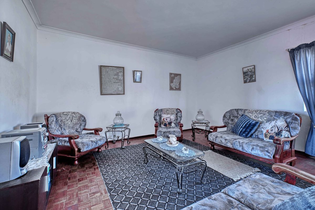 A living room featuring traditional parquet flooring and coved cornicing, offering a blank canvas for modern updates and interior design improvements.