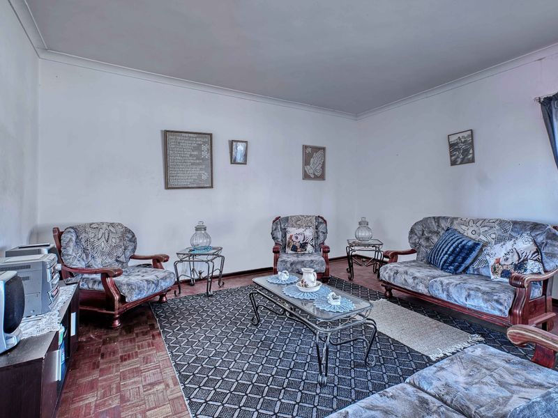 A living room featuring traditional parquet flooring and coved cornicing, offering a blank canvas for modern updates and interior design improvements.