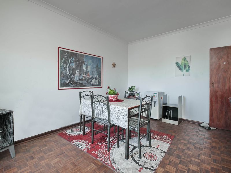 A dining room featuring classic parquet flooring and coved ceilings, offering a functional space ready for modern updates.